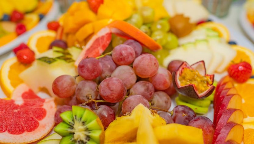 A variety of fresh fruits including grapes, kiwis, and passionfruit in a vibrant, healthy display.